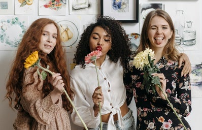 women with flowers smiling and posing