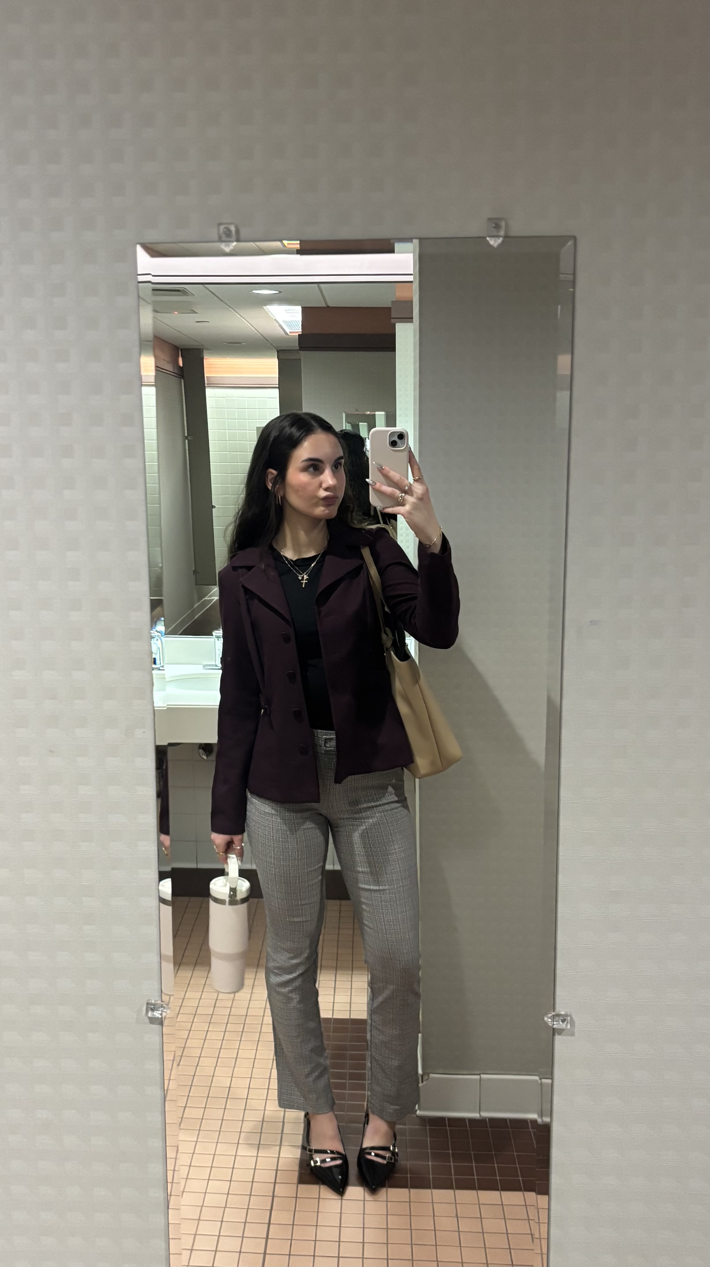 Girl posing in front of mirror taking picture of self.