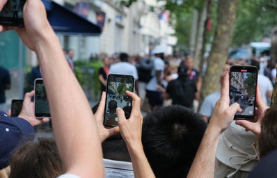 crowd of people holding up phones to take pictures