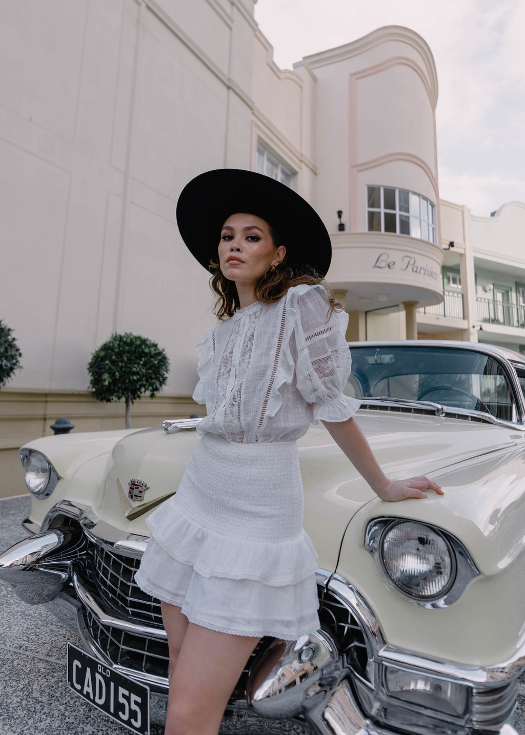 Woman in Hat and Skirt Posing by Vintage Car
