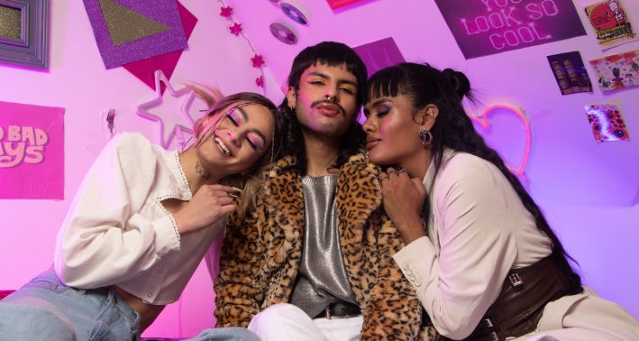 three friends sitting in a colorful and neon room