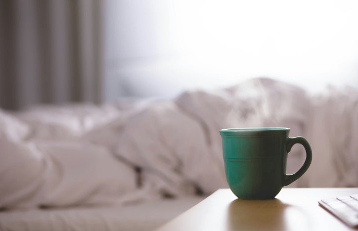 Steaming cup on nighstand by bed