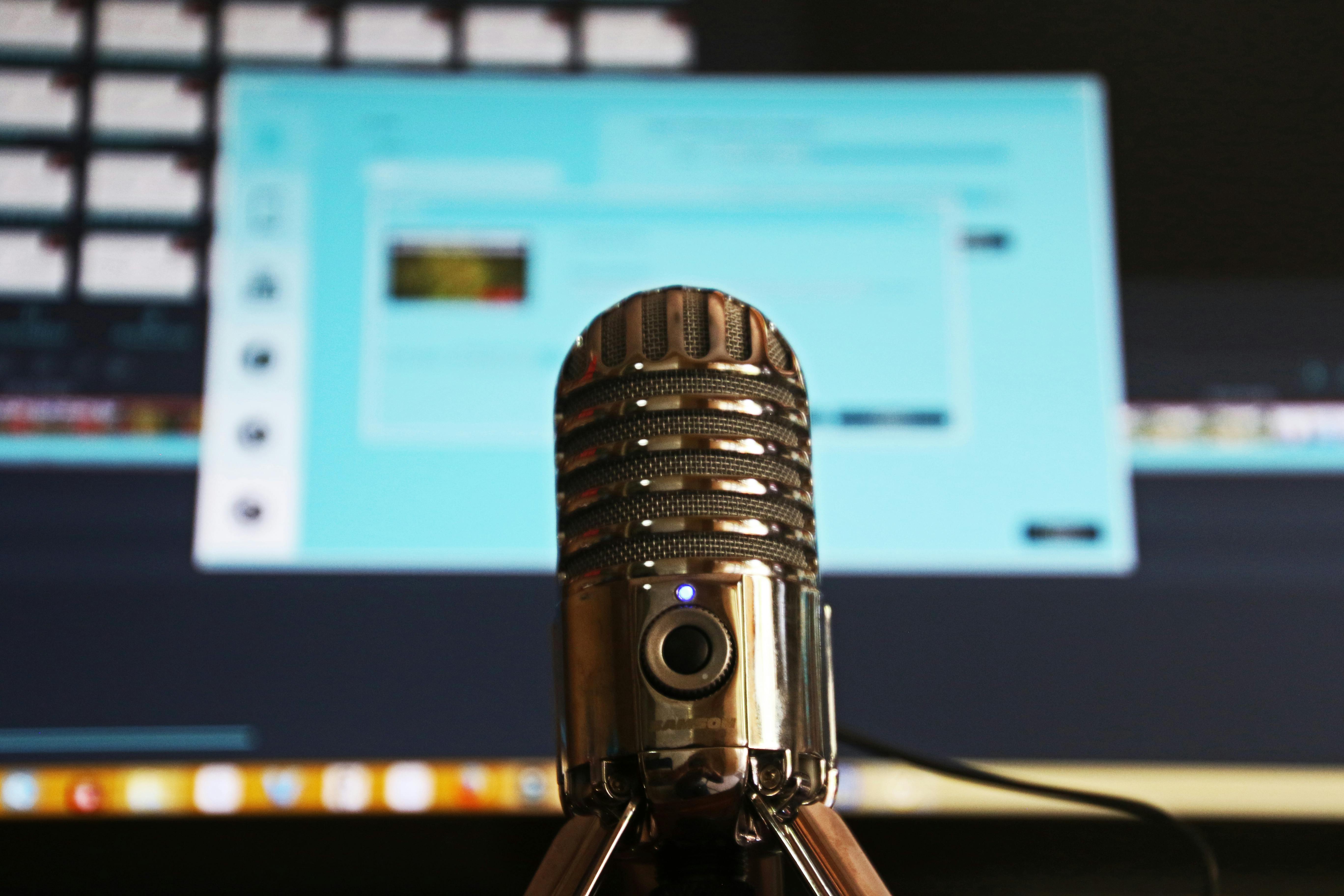 Podcast microphone in front of a computer monitor