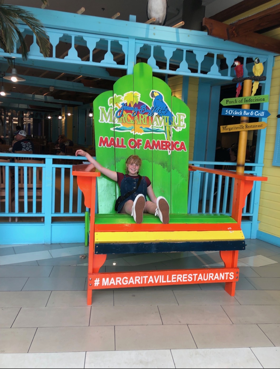 A girl sitting in a large beach chair