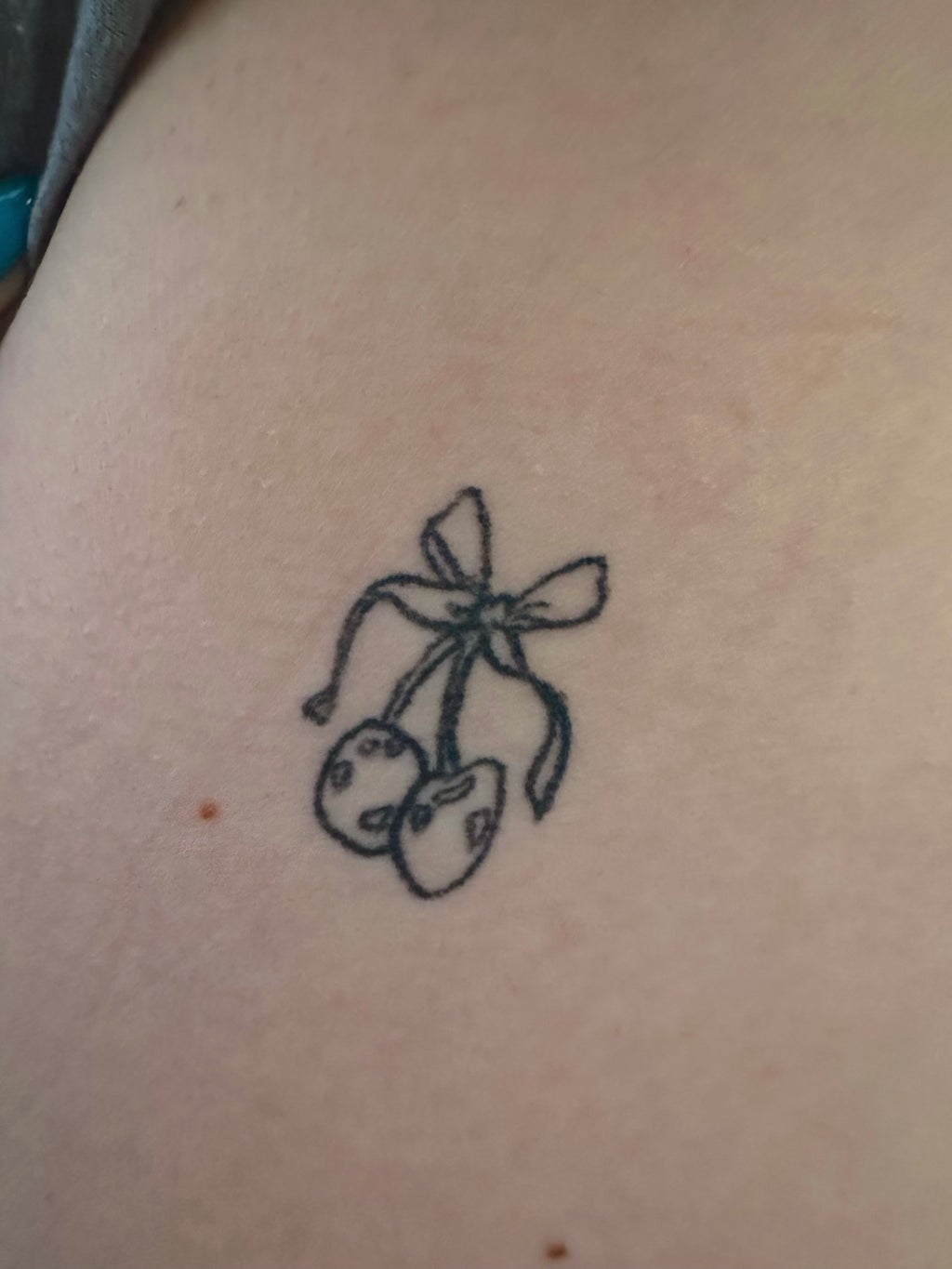 cherries with bow tattoo on left side of rib cage