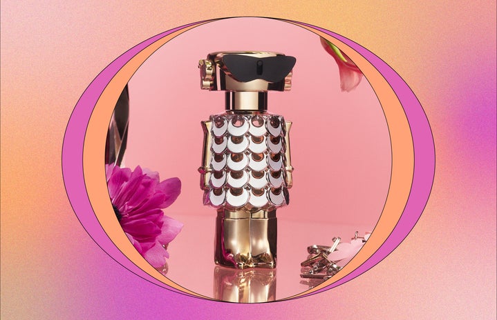 Gold perfume bottle and flowers on pink background.