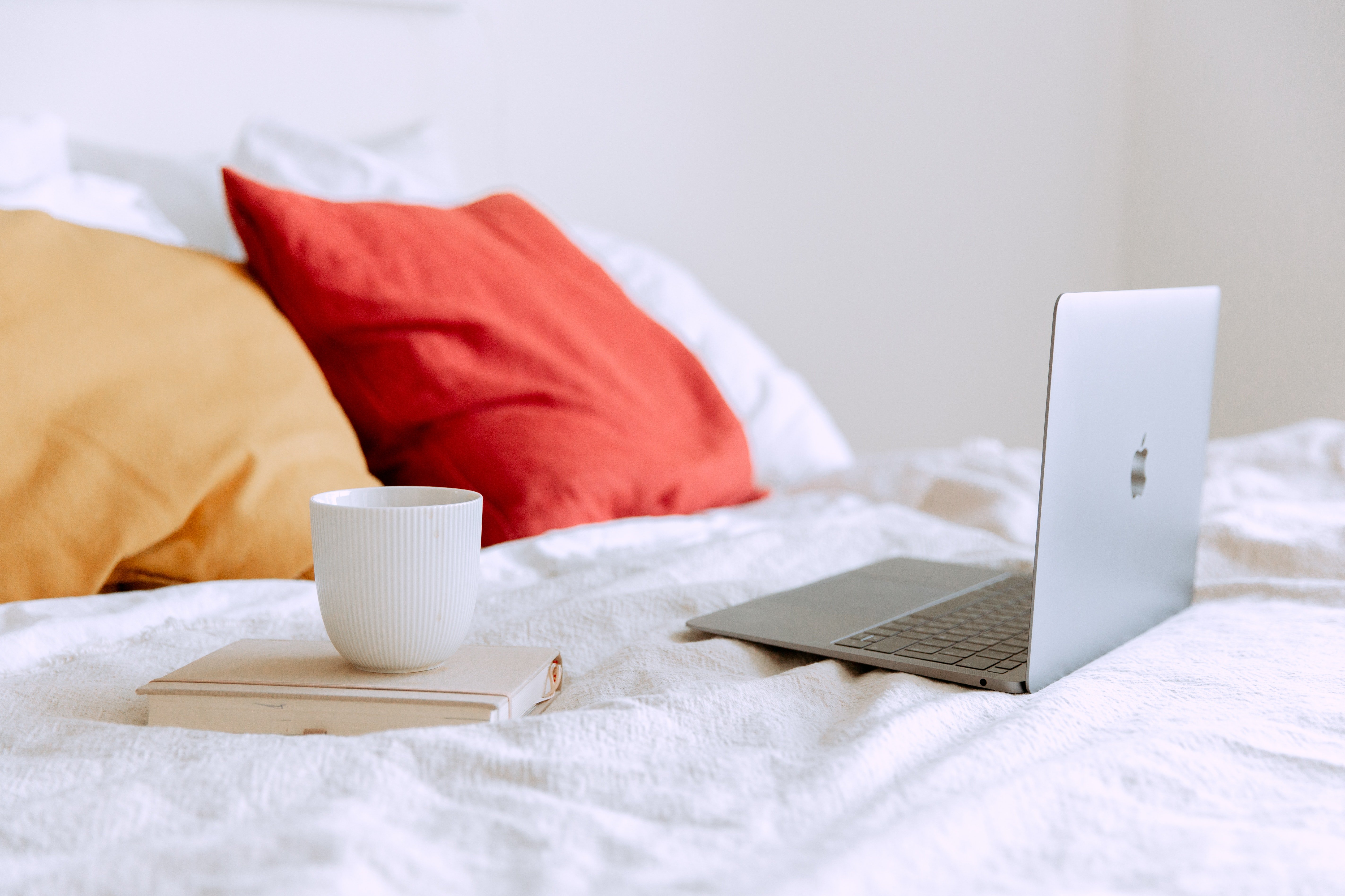 laptop on bed with a mug and book by Tatiana Syrikova?width=698&height=466&fit=crop&auto=webp&dpr=4