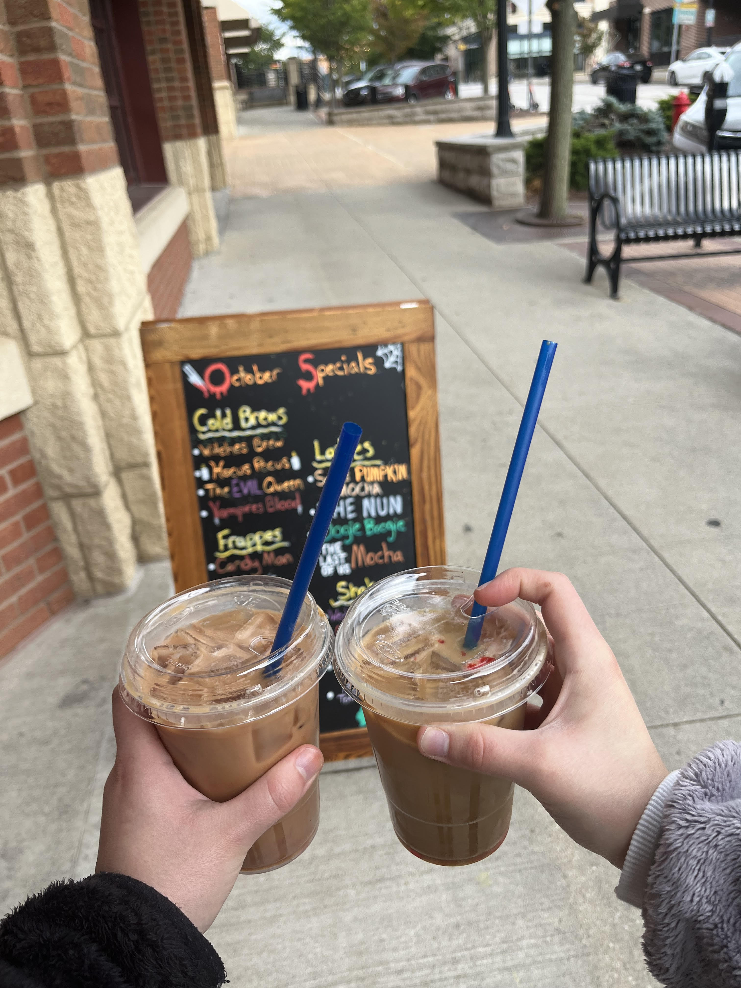 Two of the seasonal Halloween lattes in front of Tree City Coffee & Pastry.
