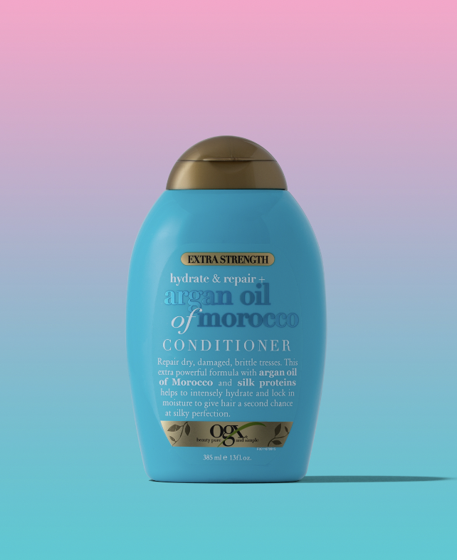 Bottle of hair product in front of an ombre pink and blue background