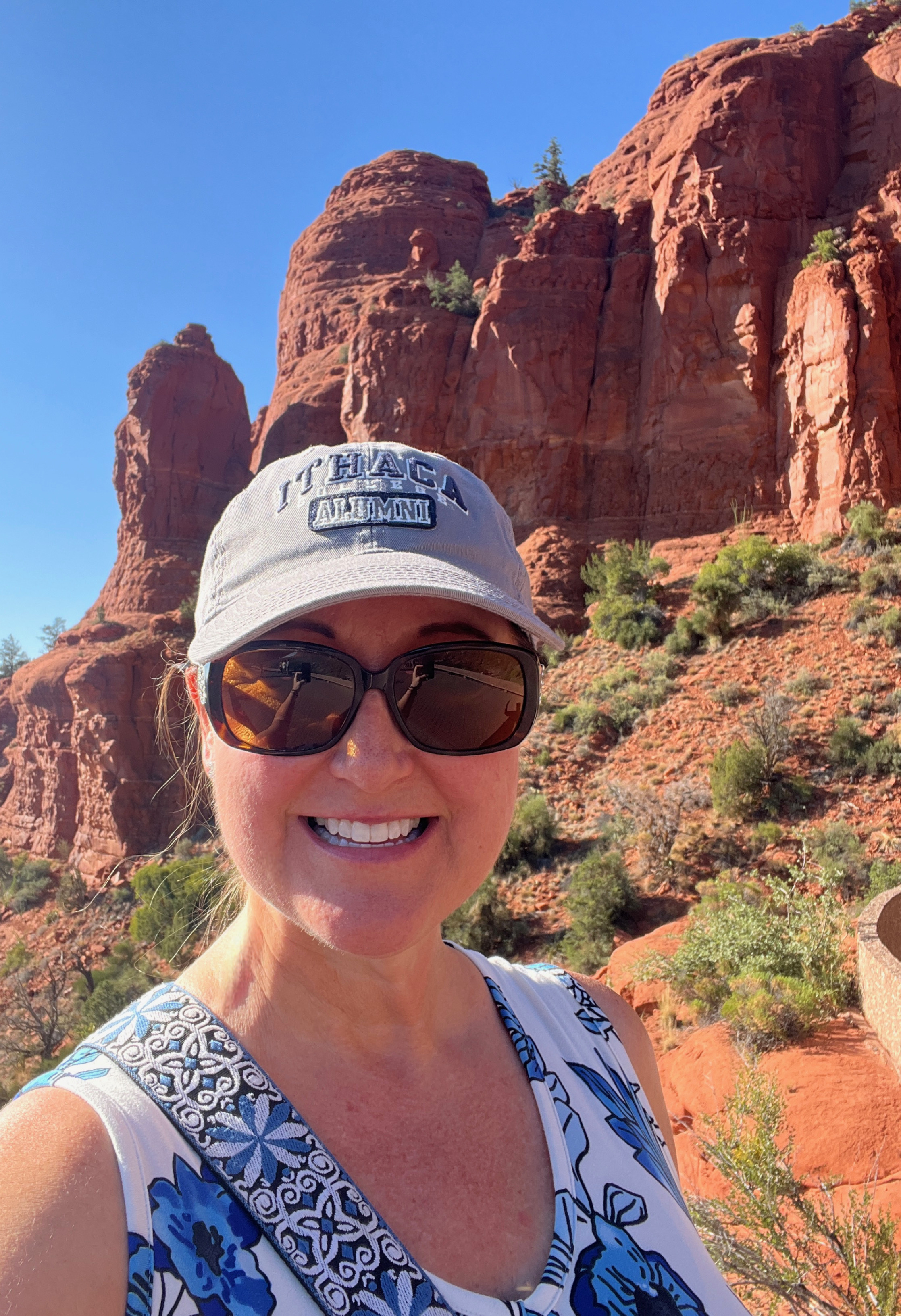 headshot of an IC alumni wearing sunglasses with a hat outside for an alumni article