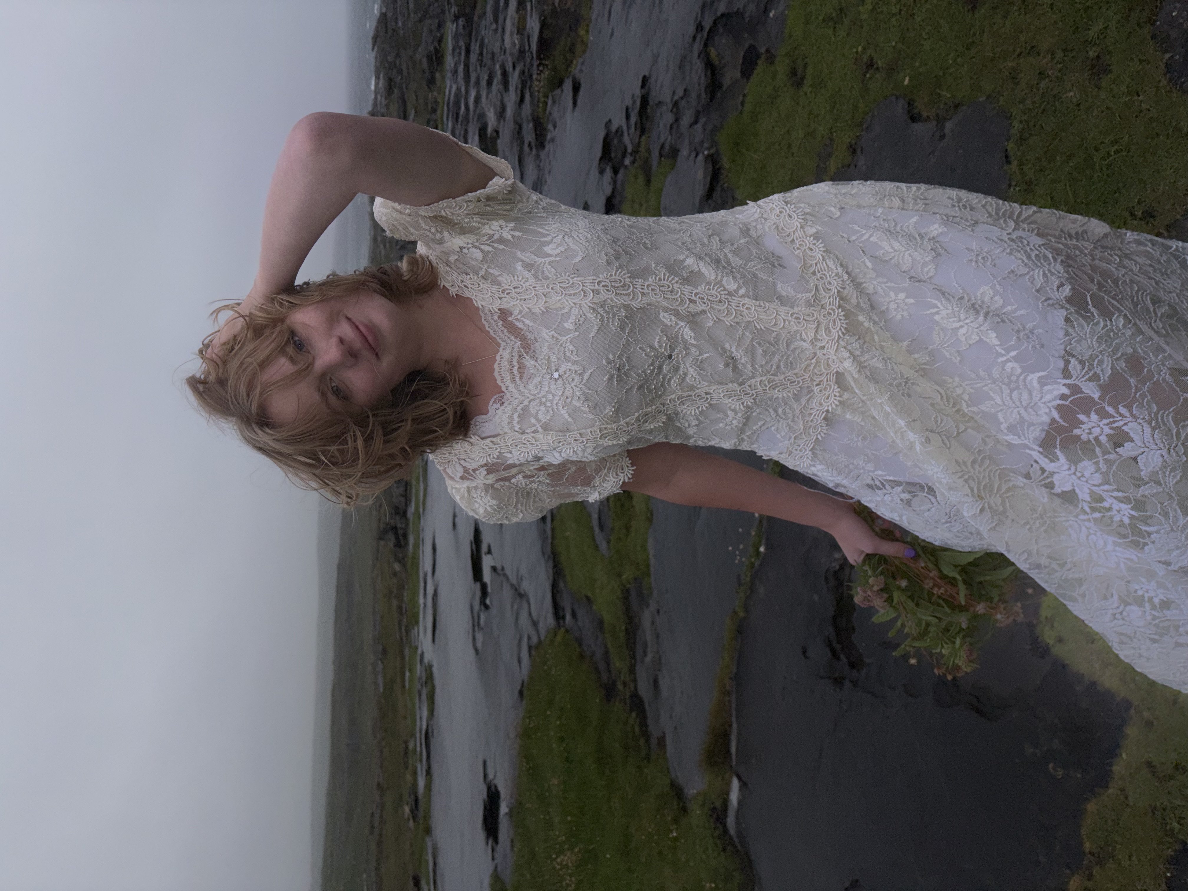 Girl standing in white dress on cliffs