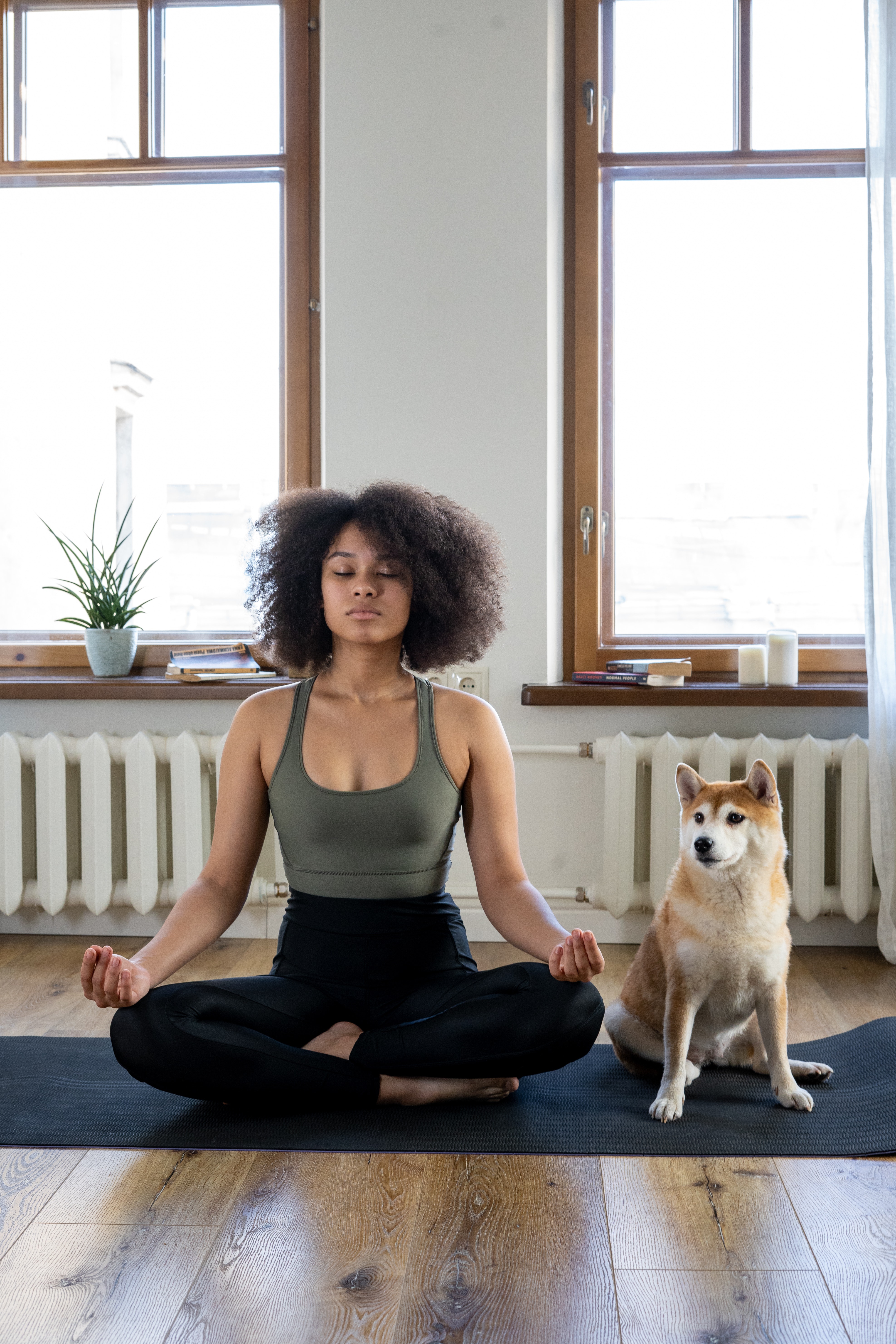 woman meditating with dog beside her