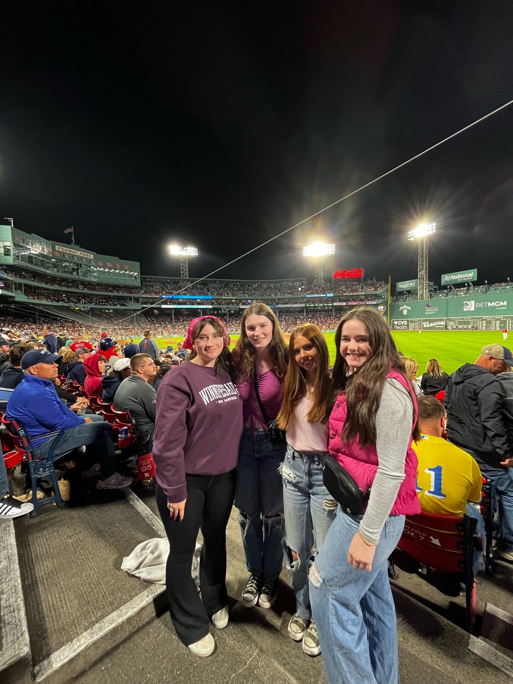 group of four girls dressed up in pink themed outfits at fenway park
