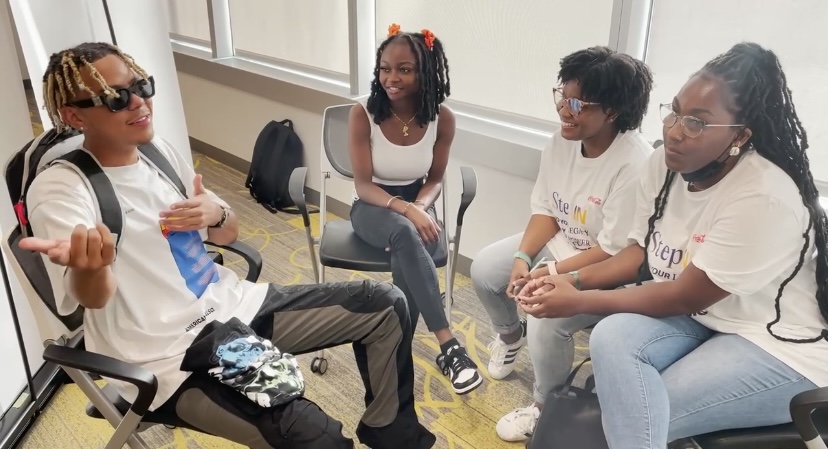 Cordae sitting with Howard University student journalists after the Kickin\' It With Cordae event.