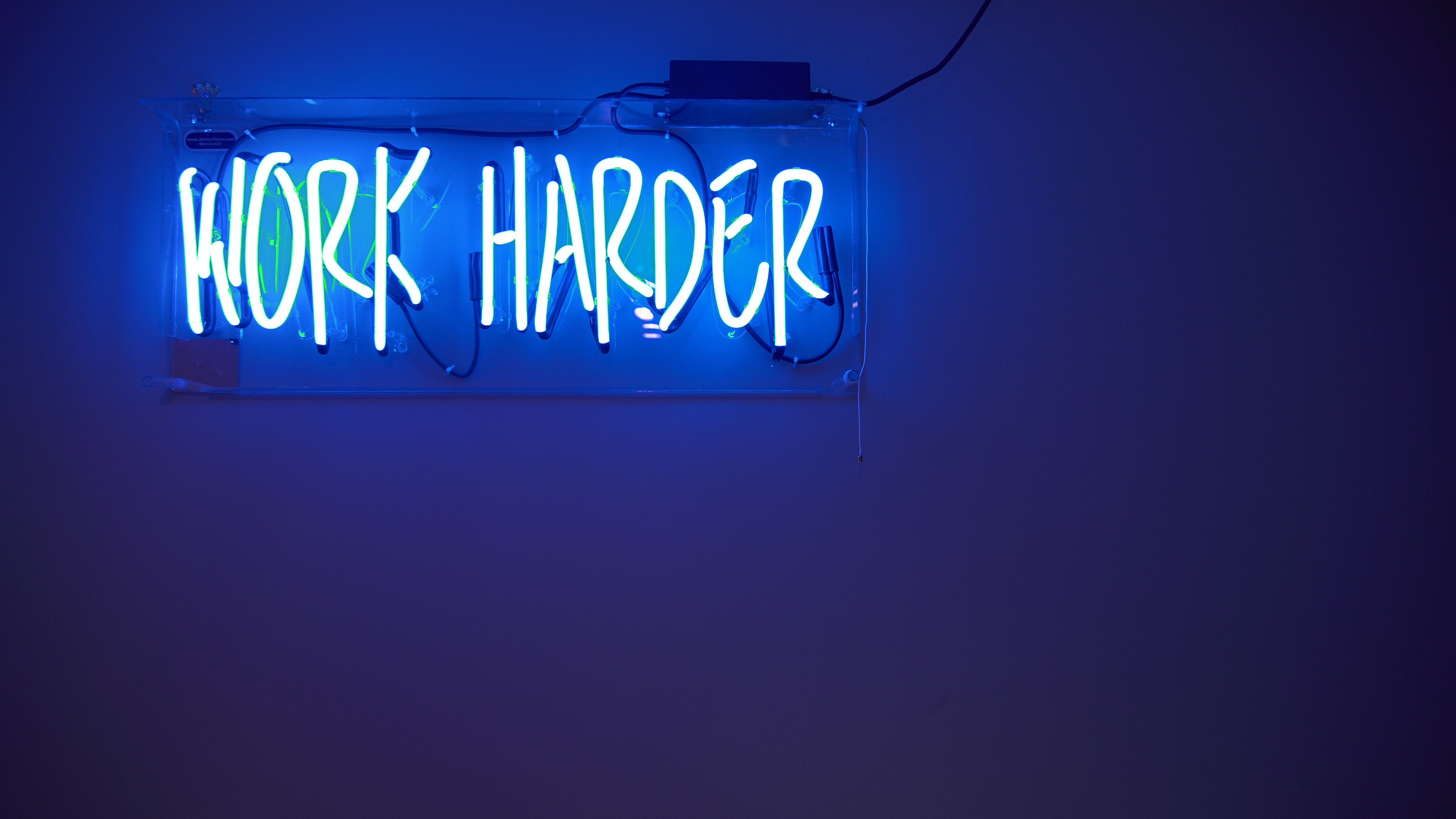work harder neon sign by Jordan Whitfield on Unsplash