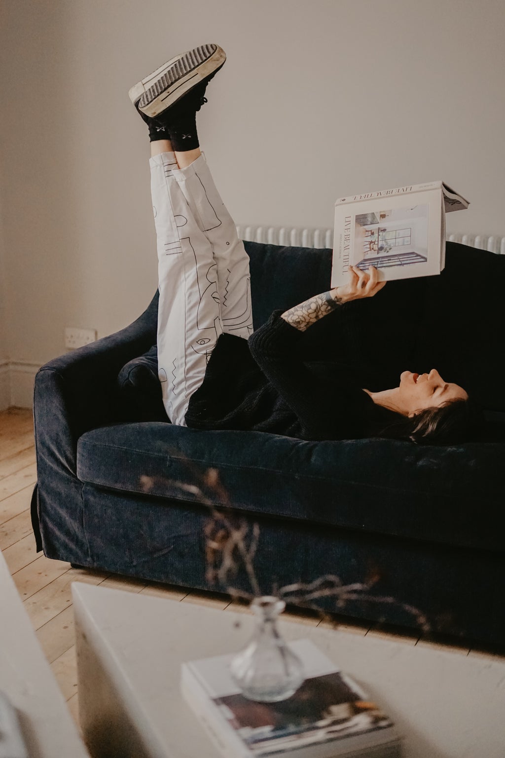 Woman lying on couch reading
