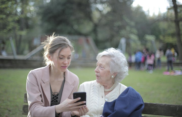 Daughter teaching her old mother how to use a cellphone