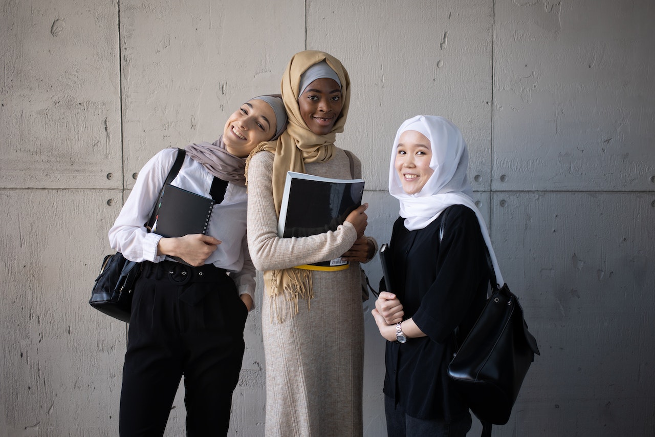 muslim women posing together with books