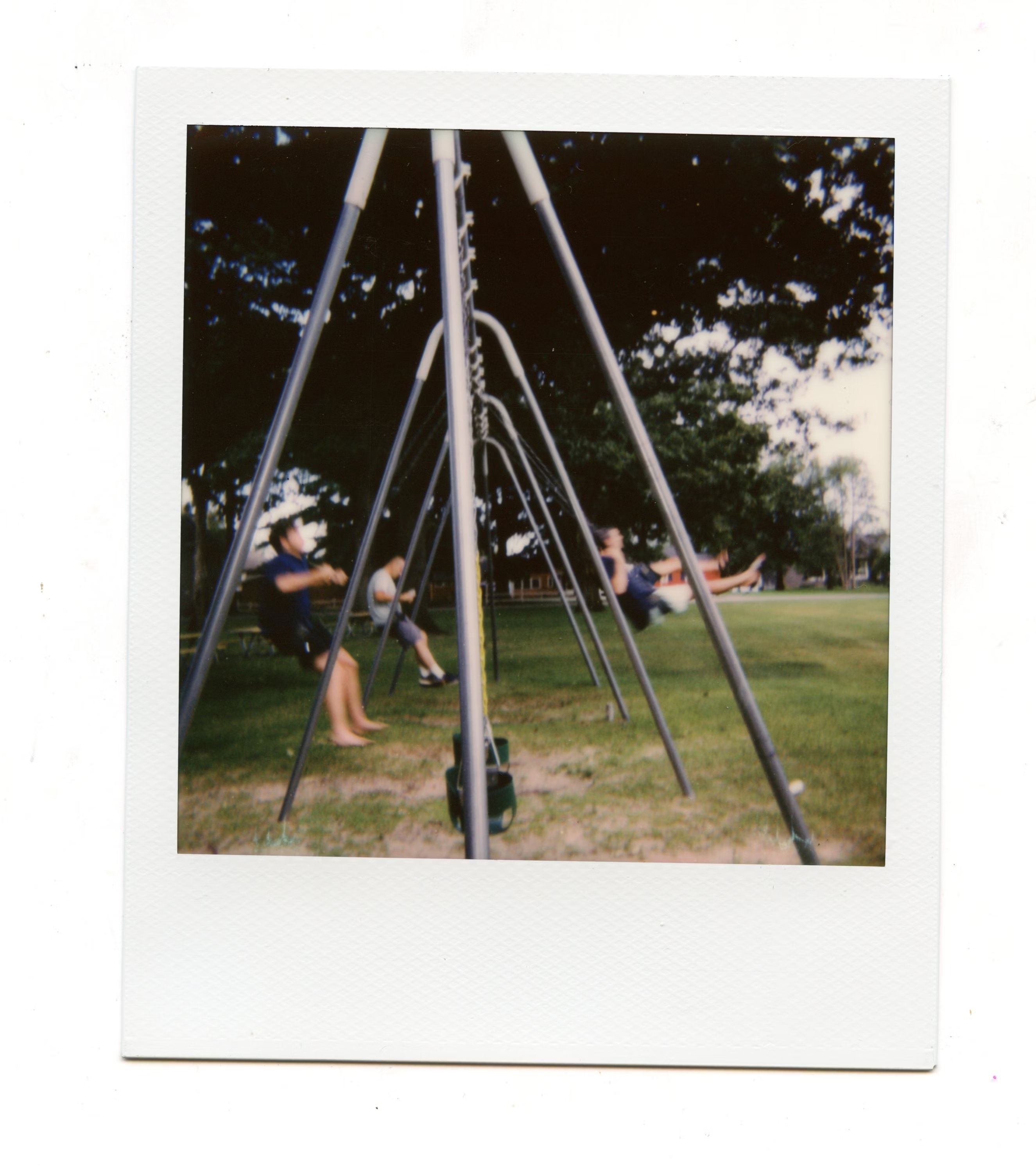 polaroid picture of friends in a swing from a different angle