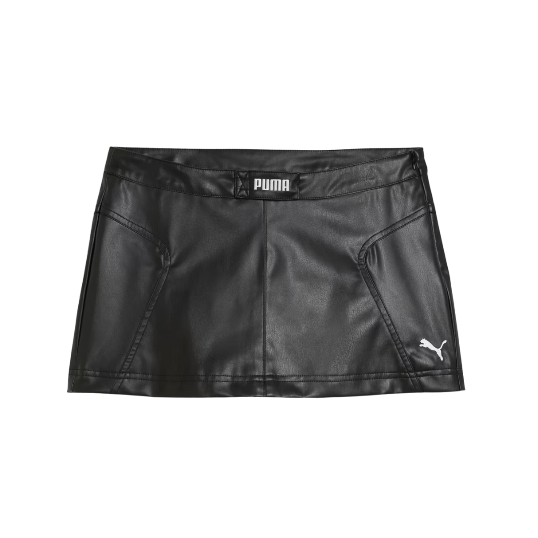Black leather-look mini skirt with diagonal front pockets. Features white Puma logo on the bottom right and PUMA label at the waistband, conveying a sleek, sporty style.