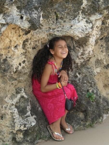 childhood image of young girl smiling at the beach