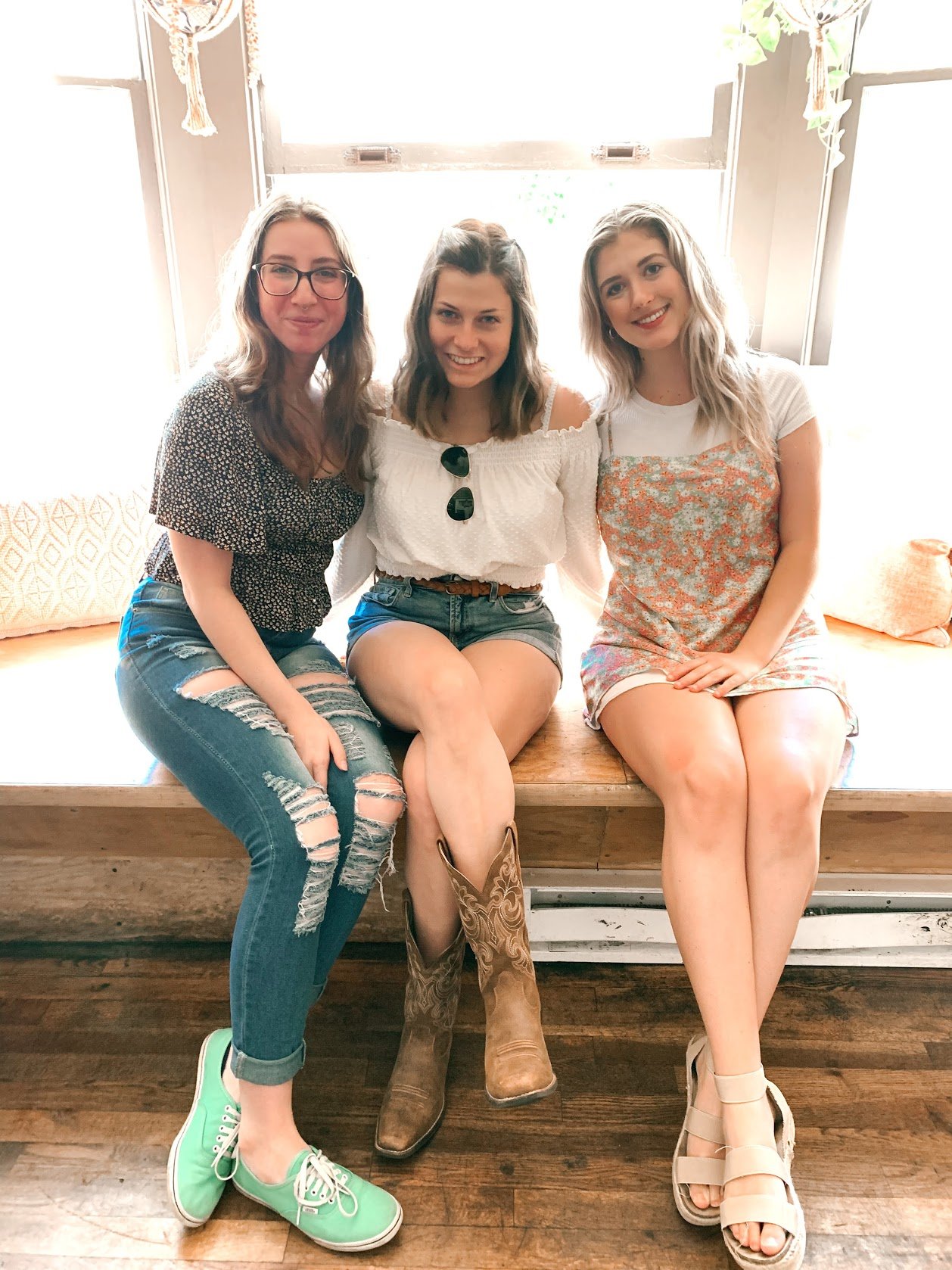 Kaitlyn, Maeve and Katelynn sitting on a bench in front of the window n the restaurant