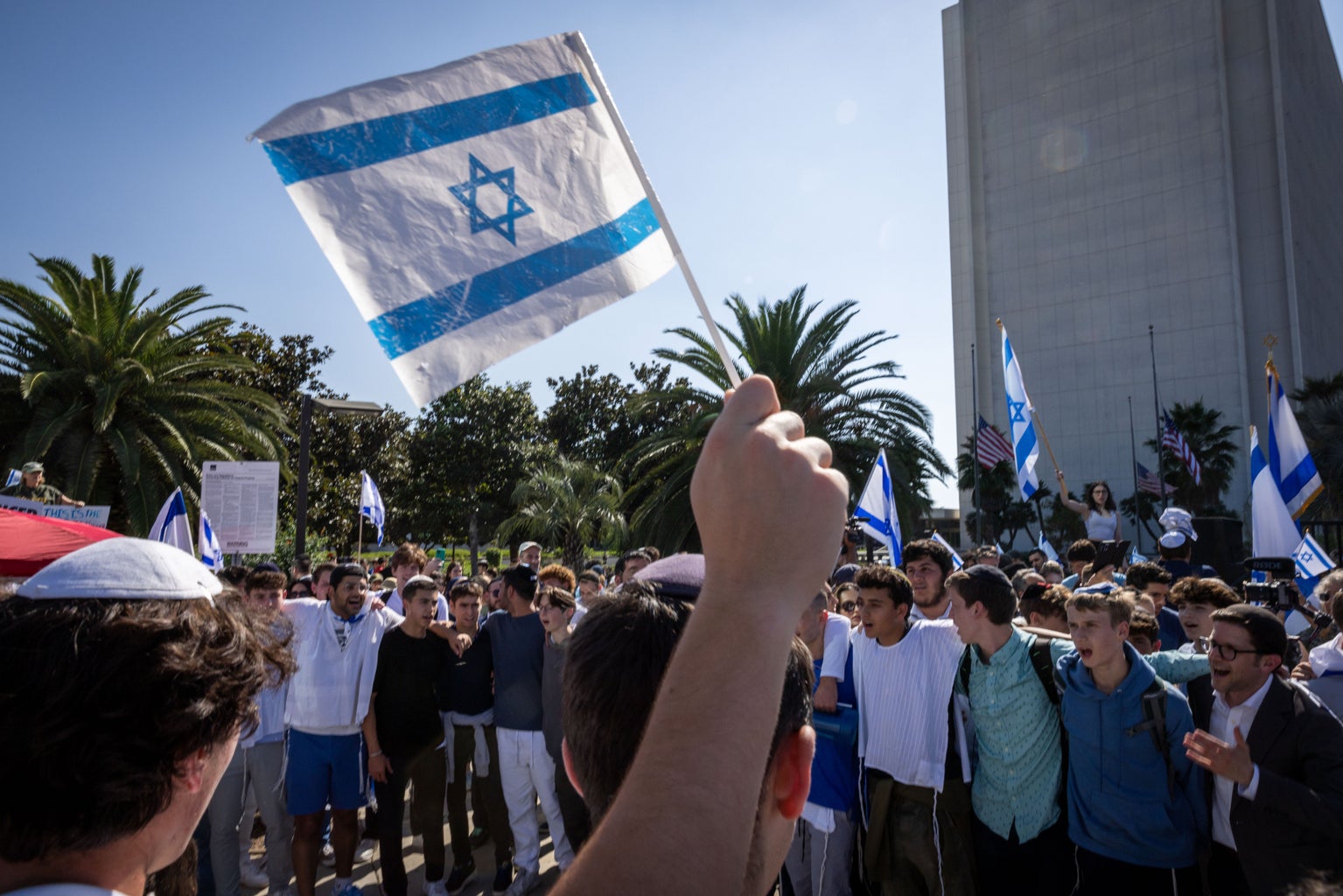 israeli flag in front of a crowd of protesters