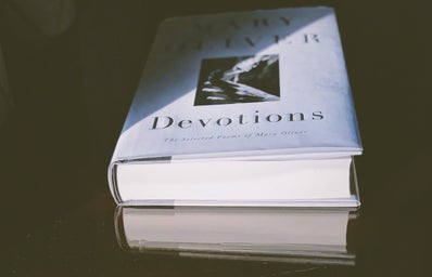Mary Oliver\'s book Devotions laying on a table