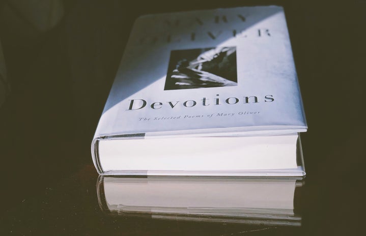 Mary Oliver\'s book Devotions laying on a table