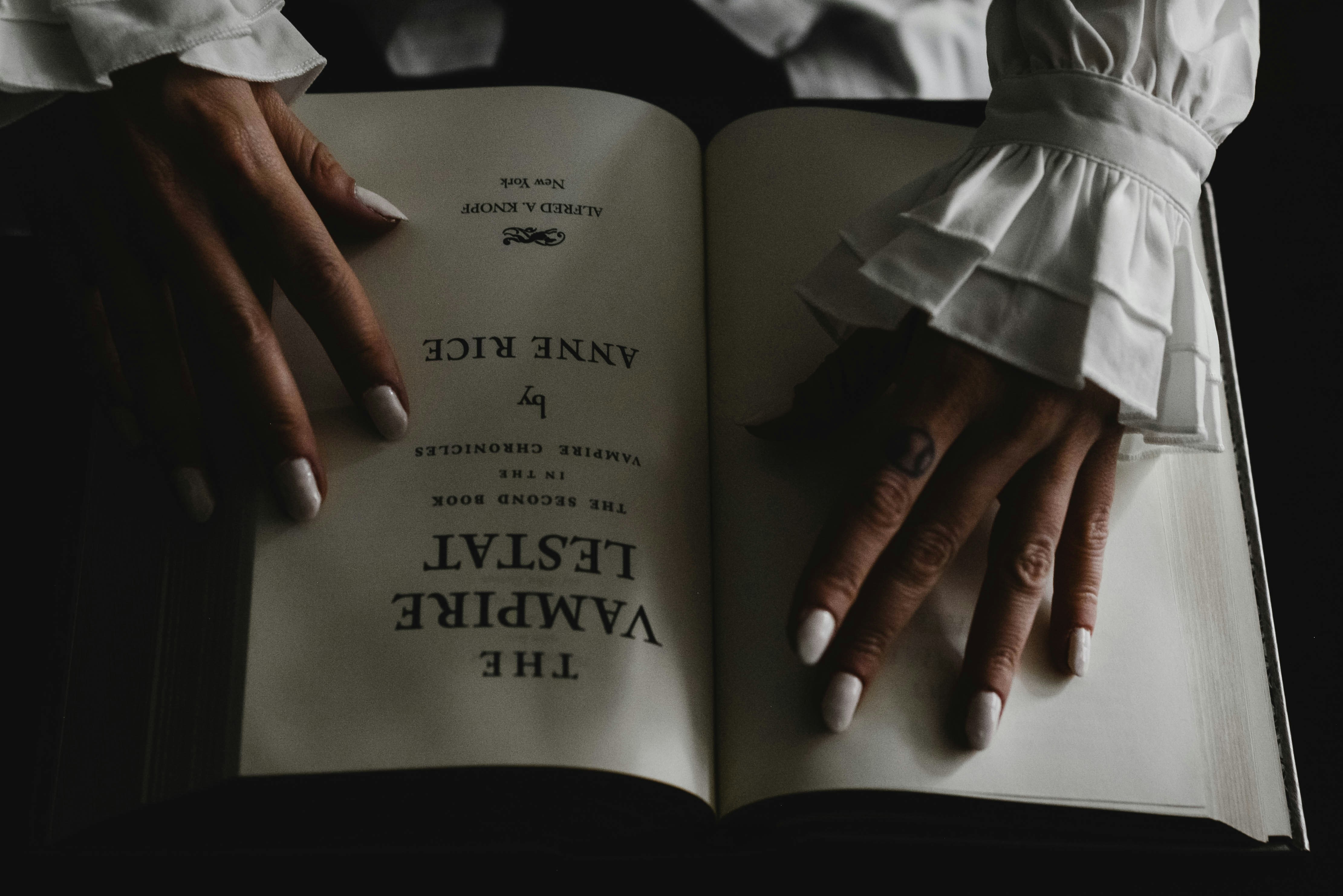 Vampire hands laying on book