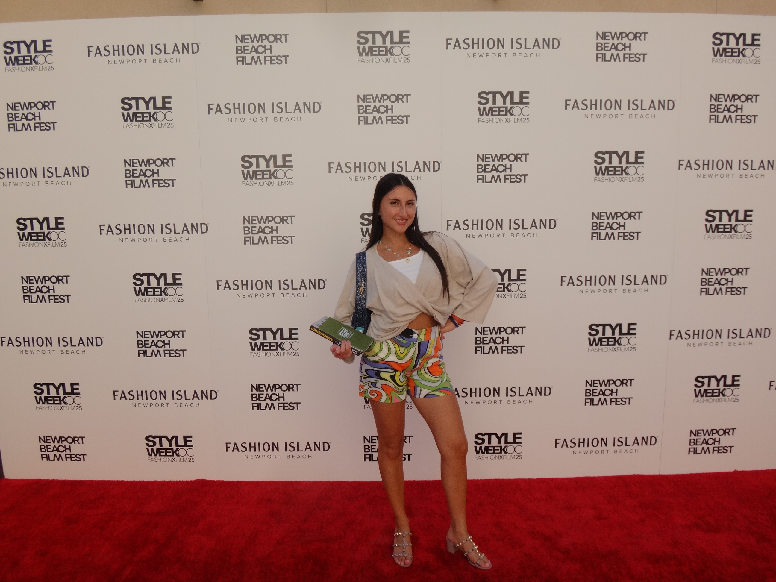 A woman posing behind backdrop