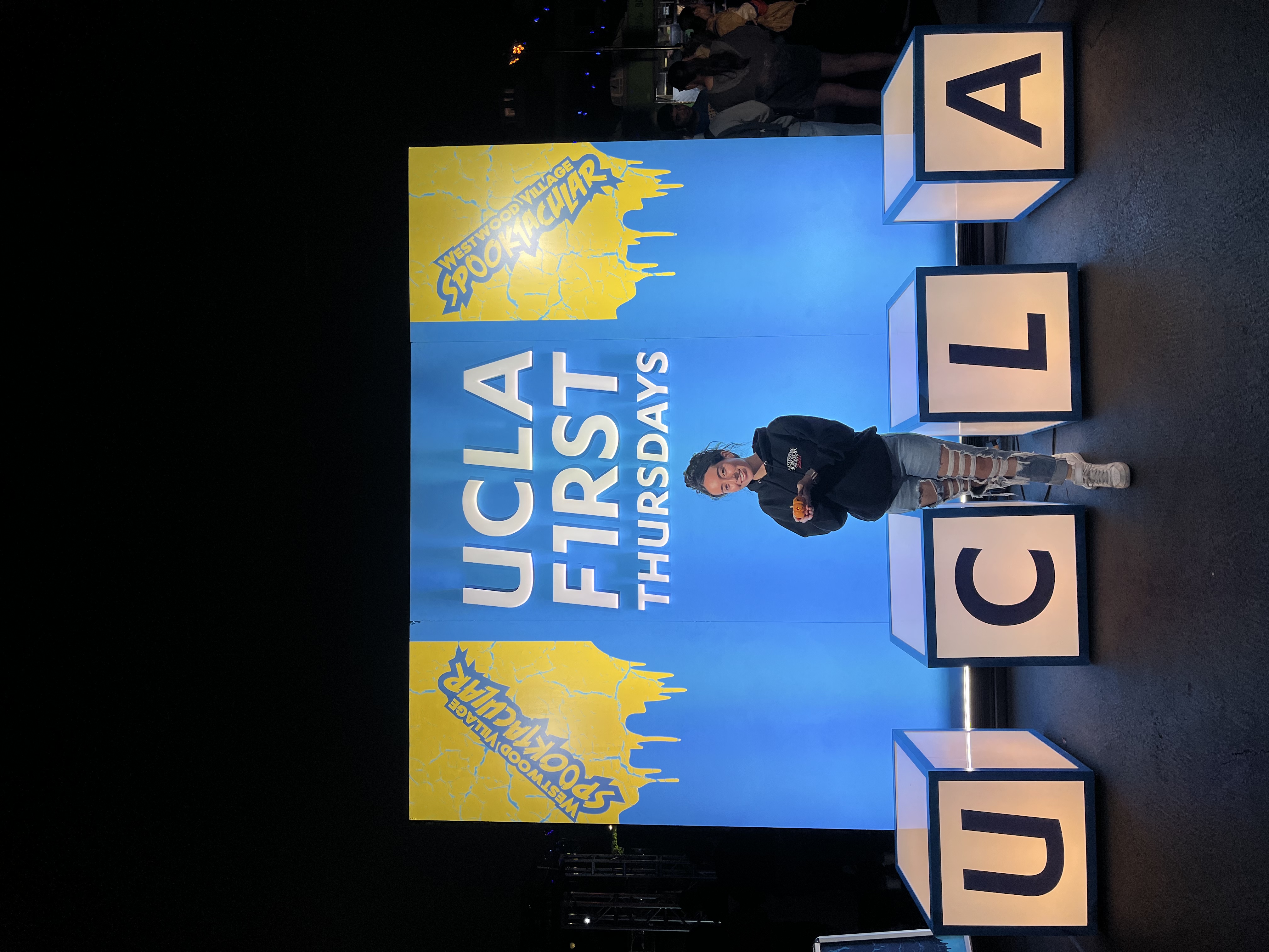 Young girl posing with a pumpkin in front of the event’s entrance.