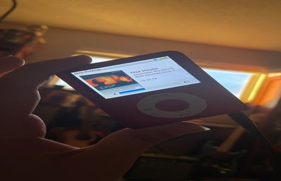 Red iPod Nano (3rd Generation) being held up against golden hour light coming from window