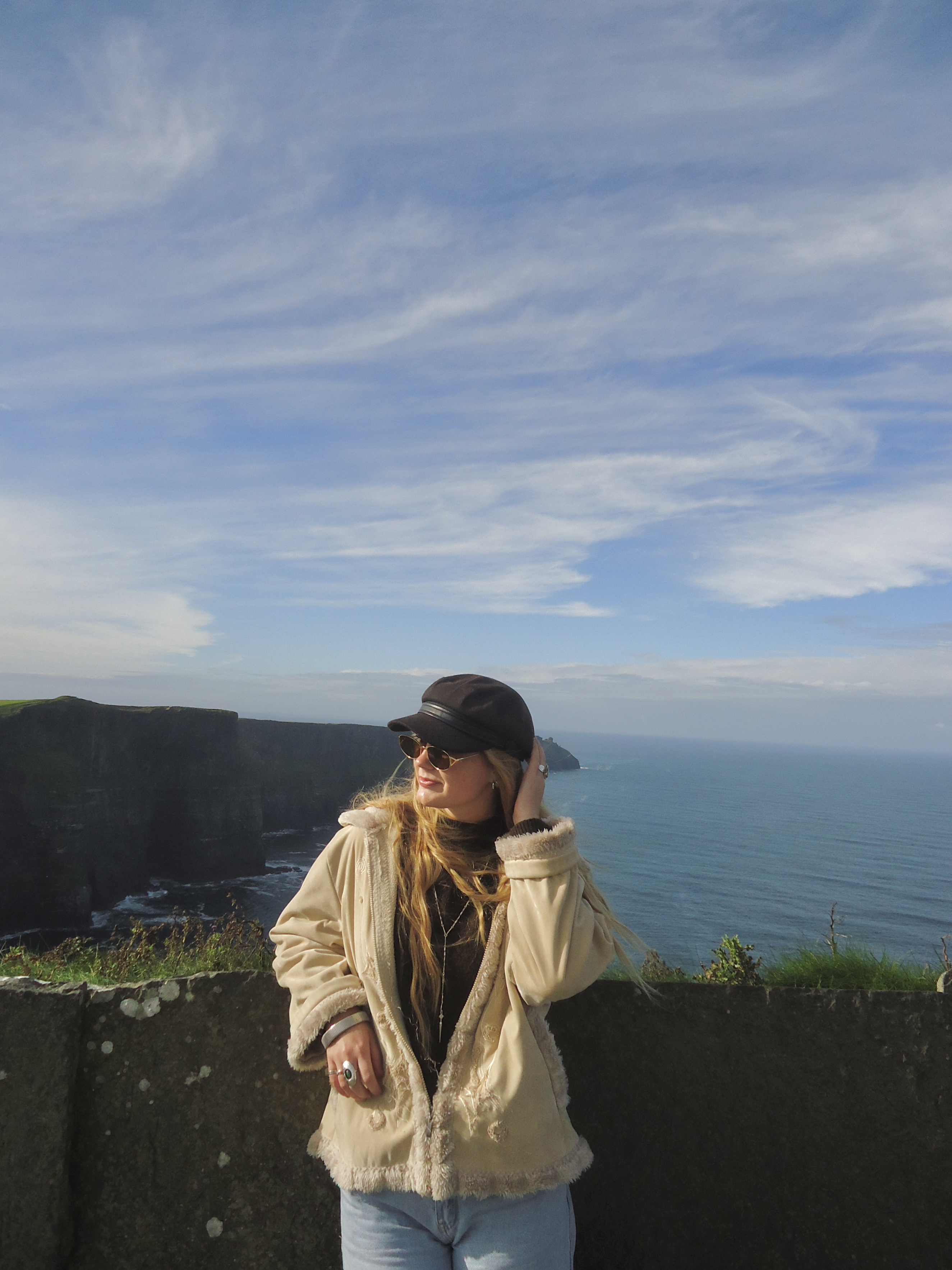 woman standing in front of Ireland’s Cliffs of Moher tourist site