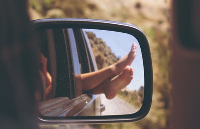 Person\'s leg resting on car window
