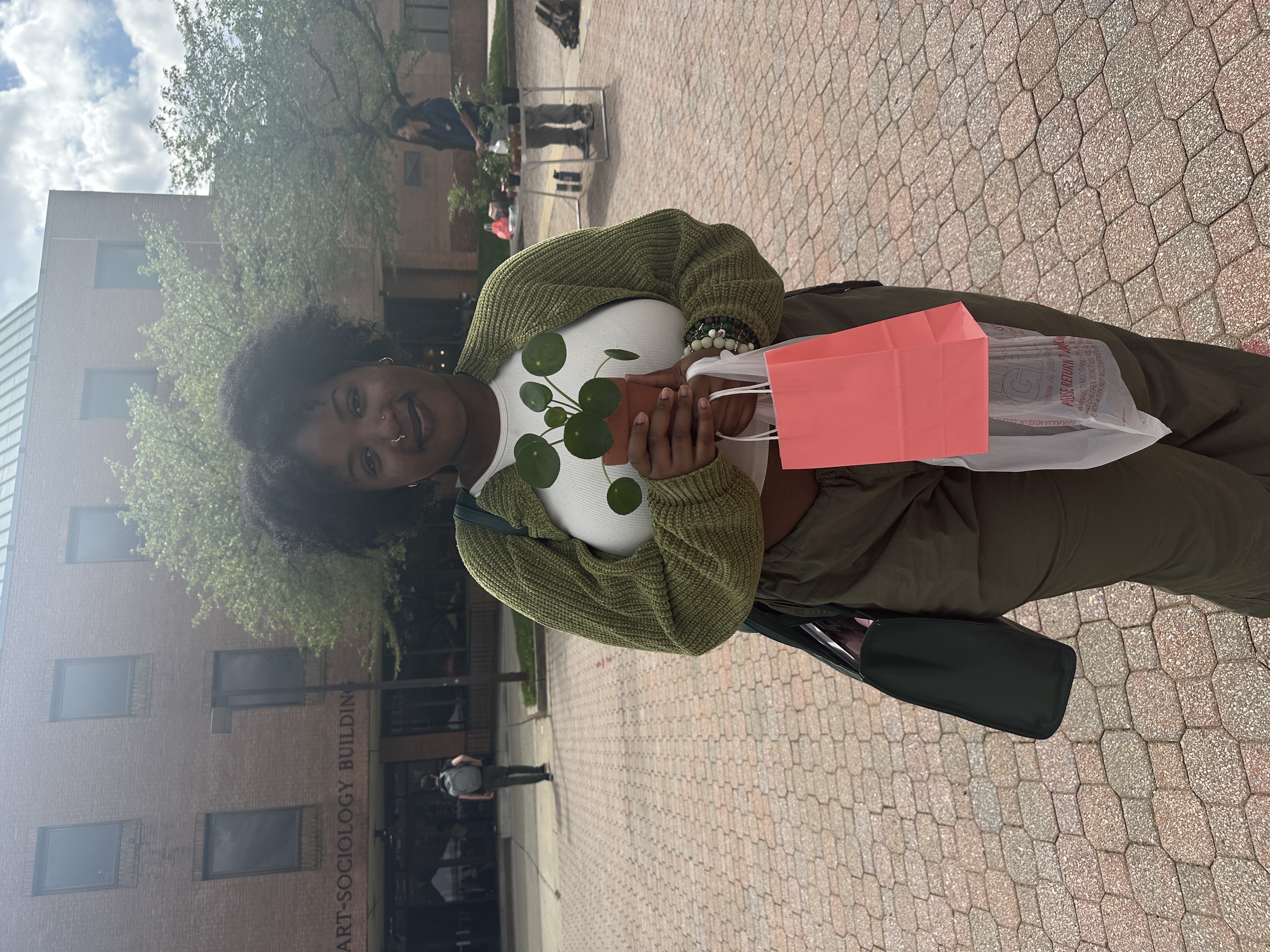 Cuttis Plants costumer, Louise Ndovie purchases a Chinese Money Plant and poses with her new possesion.