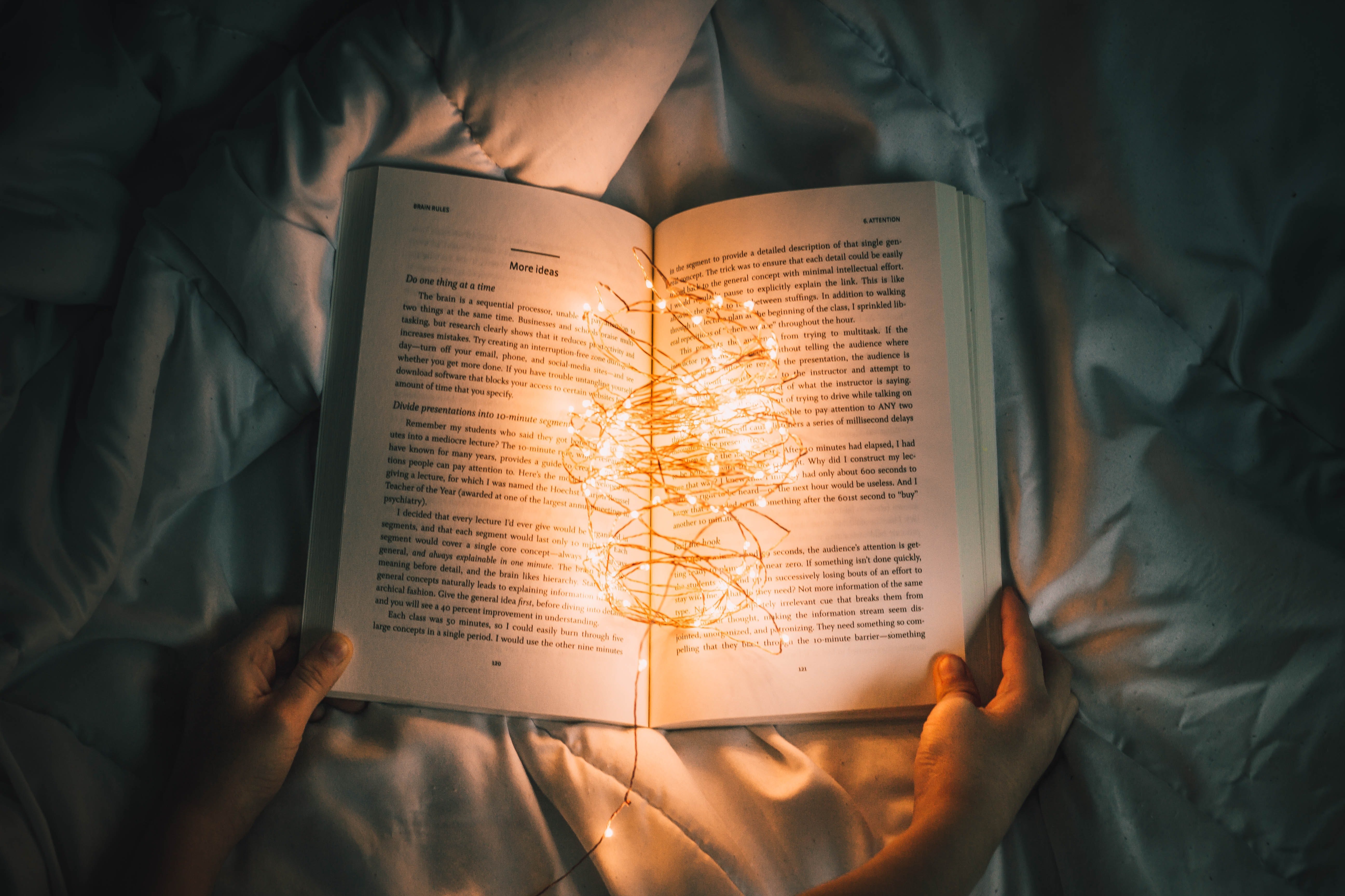 book on a bed illuminated with tiny lights by Unsplash