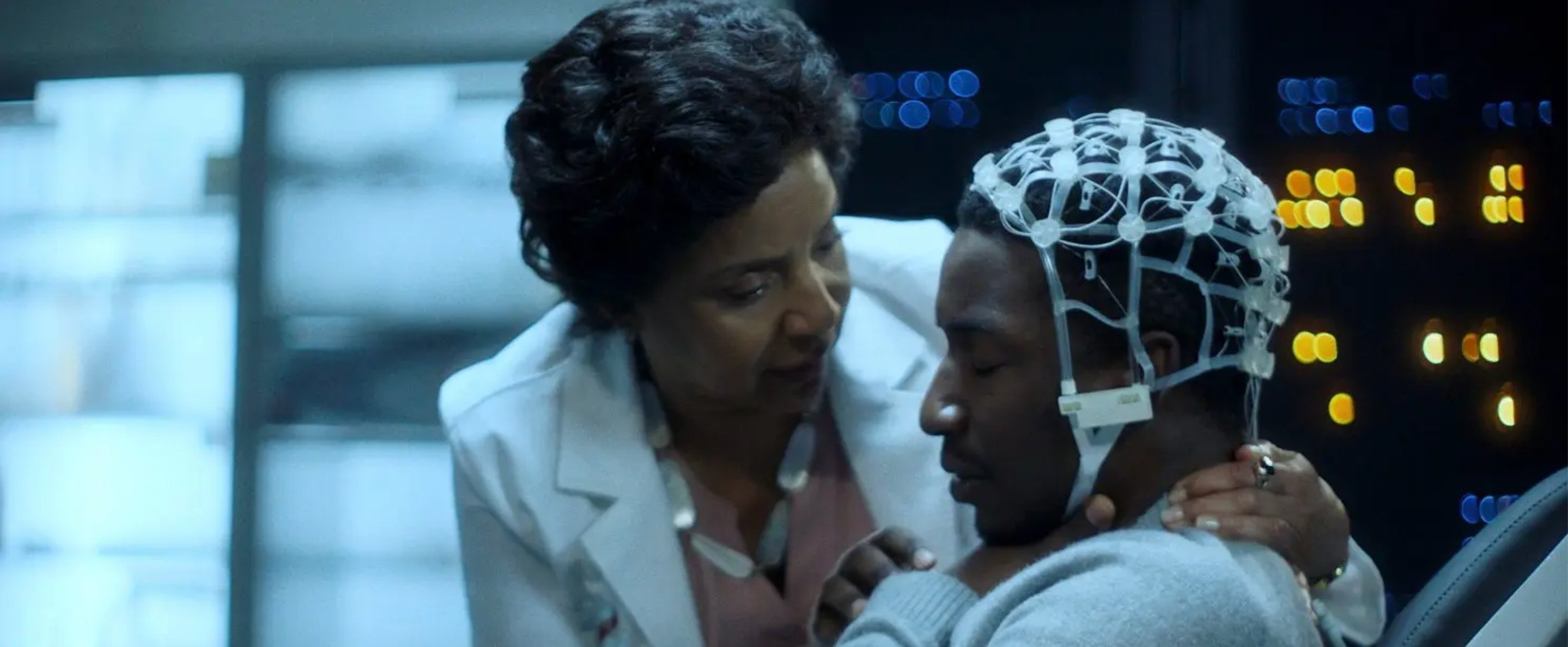 Still from Black Box; Specifically the image of Nolan with the EEG cap on and the doctor, Lillian, speaking to him.