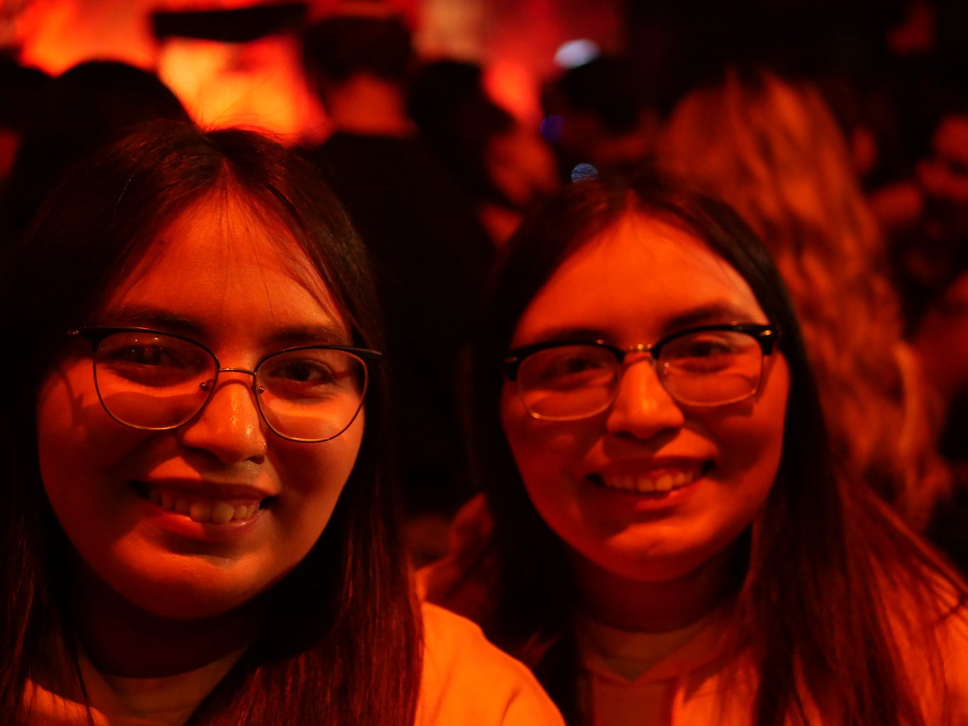 two girls smiling under red lighting