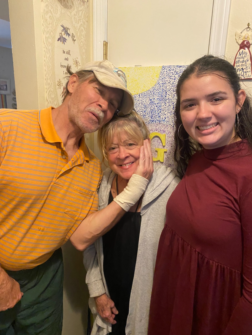 Granddaughter standing smiling next to her grandparents