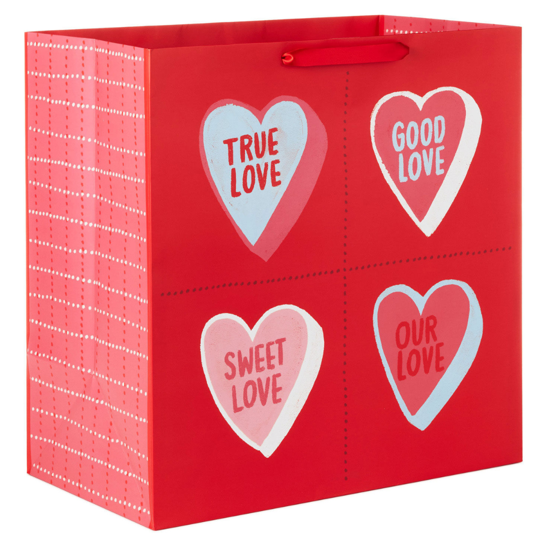 red gift back with multi-colored conversation hearts that read \