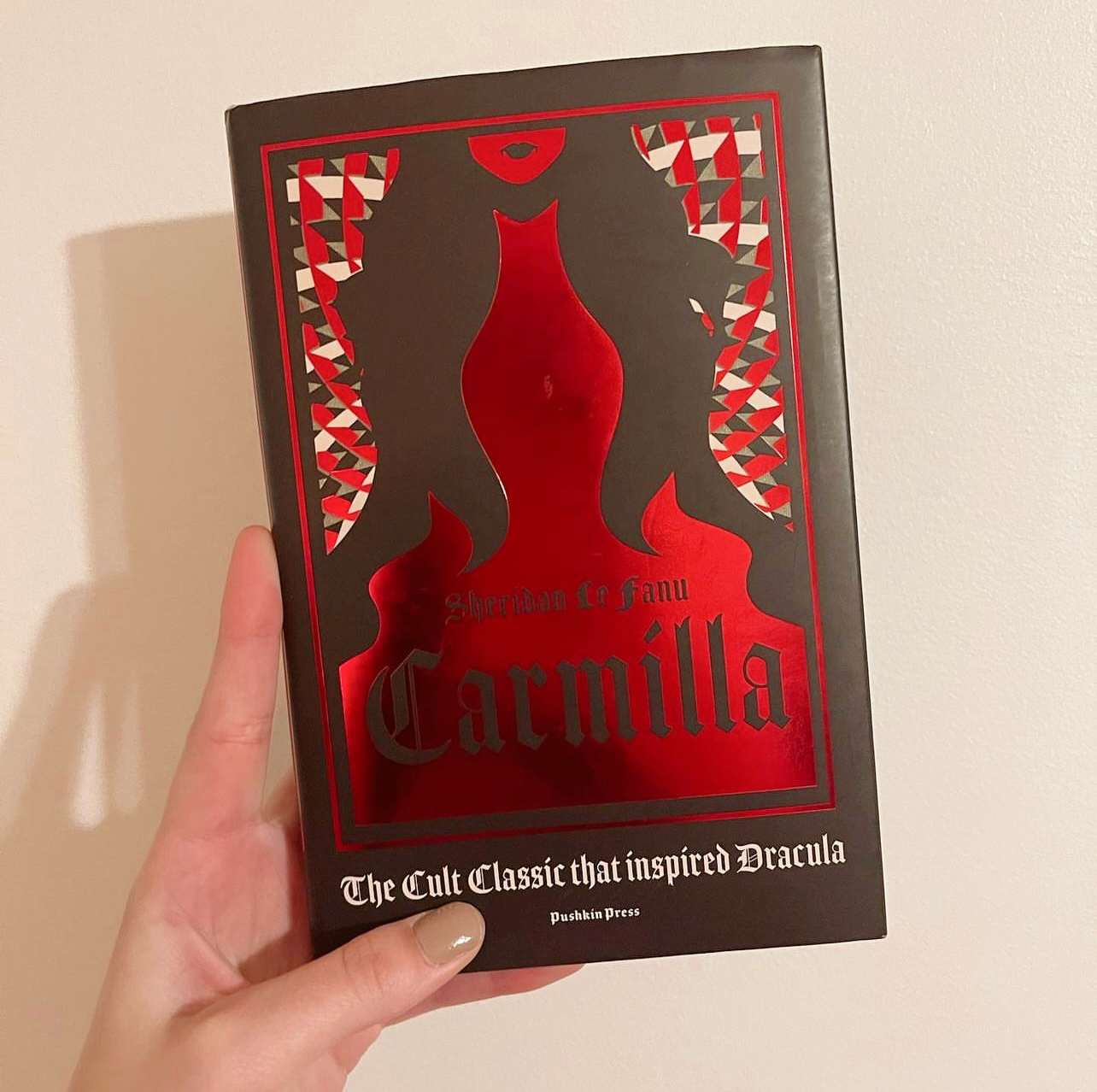 Photo of hand holding book. Carmilla