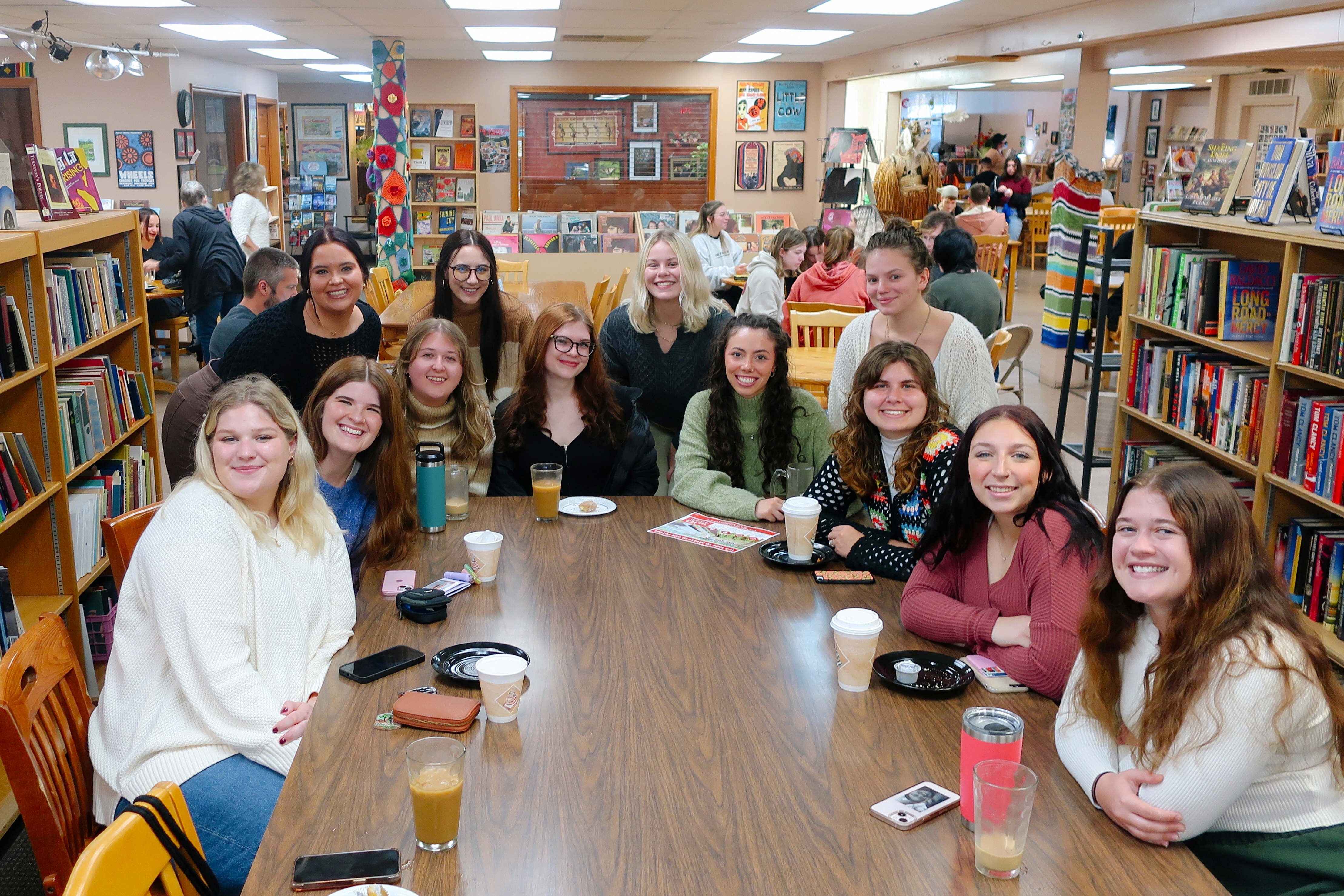 Women at coffee shop/bookstore smiling at camera