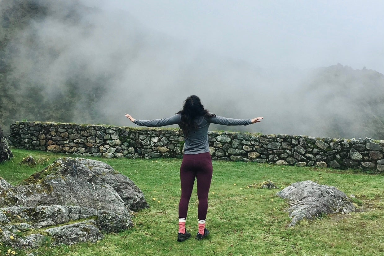 Girl standing on ruins in Peru.