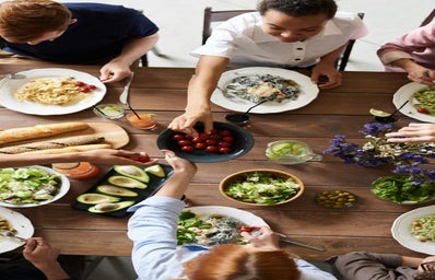 dinner table with food on it and people sitting around eating