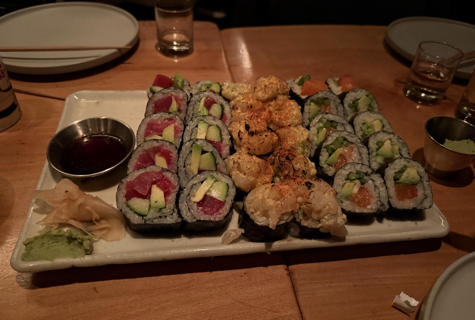 A platter of sushi on a dimly-lit table