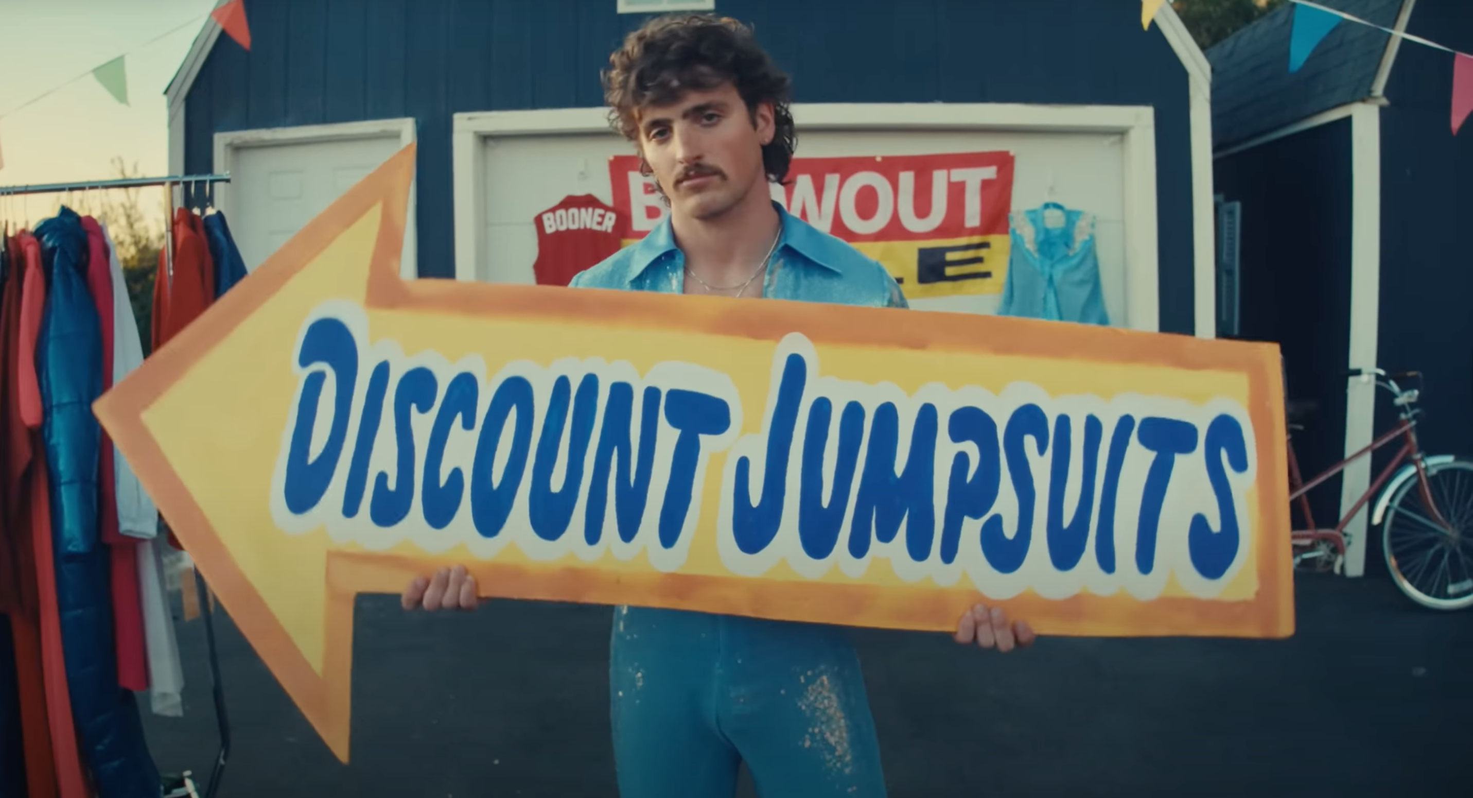Singer Benson Boone holding a sign saying \