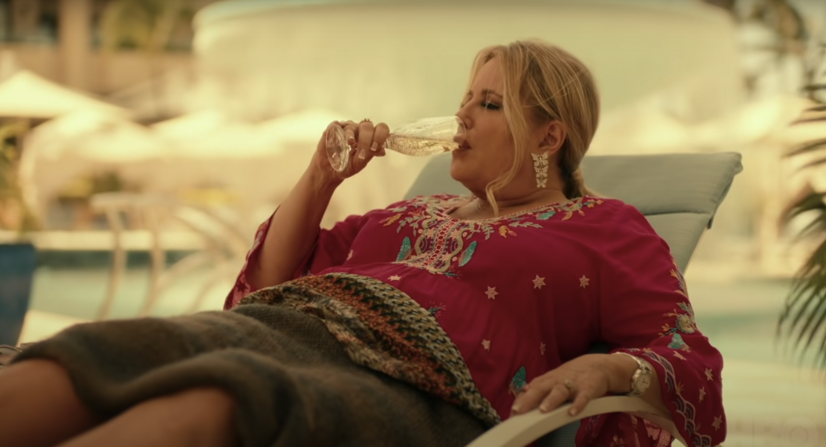 Woman sitting in lounge chair sipping wine.