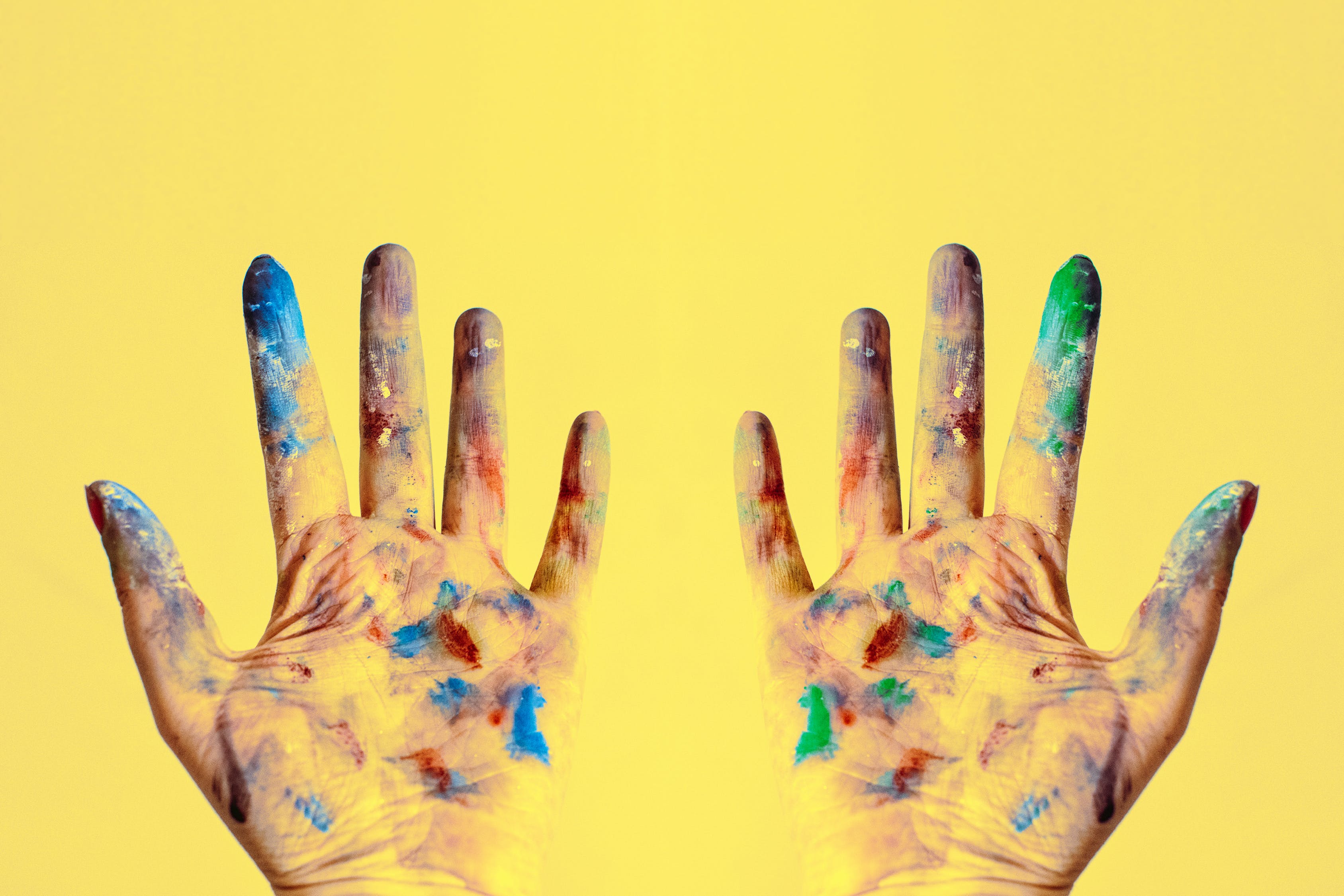 paint-splattered gloves against yellow background