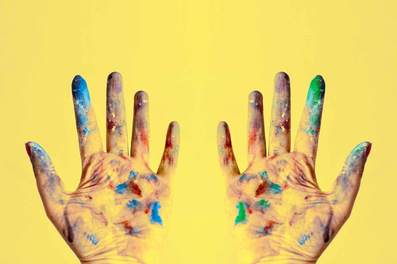 paint-splattered gloves against yellow background